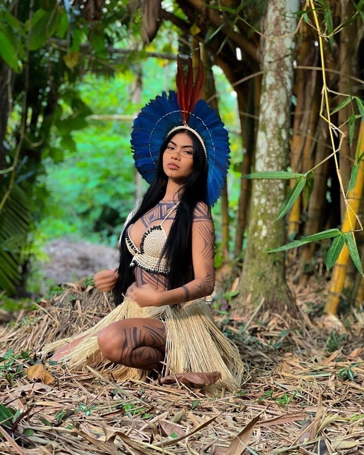 Jazmine in traditional island feather headdress and grass skirt deep in the jungle